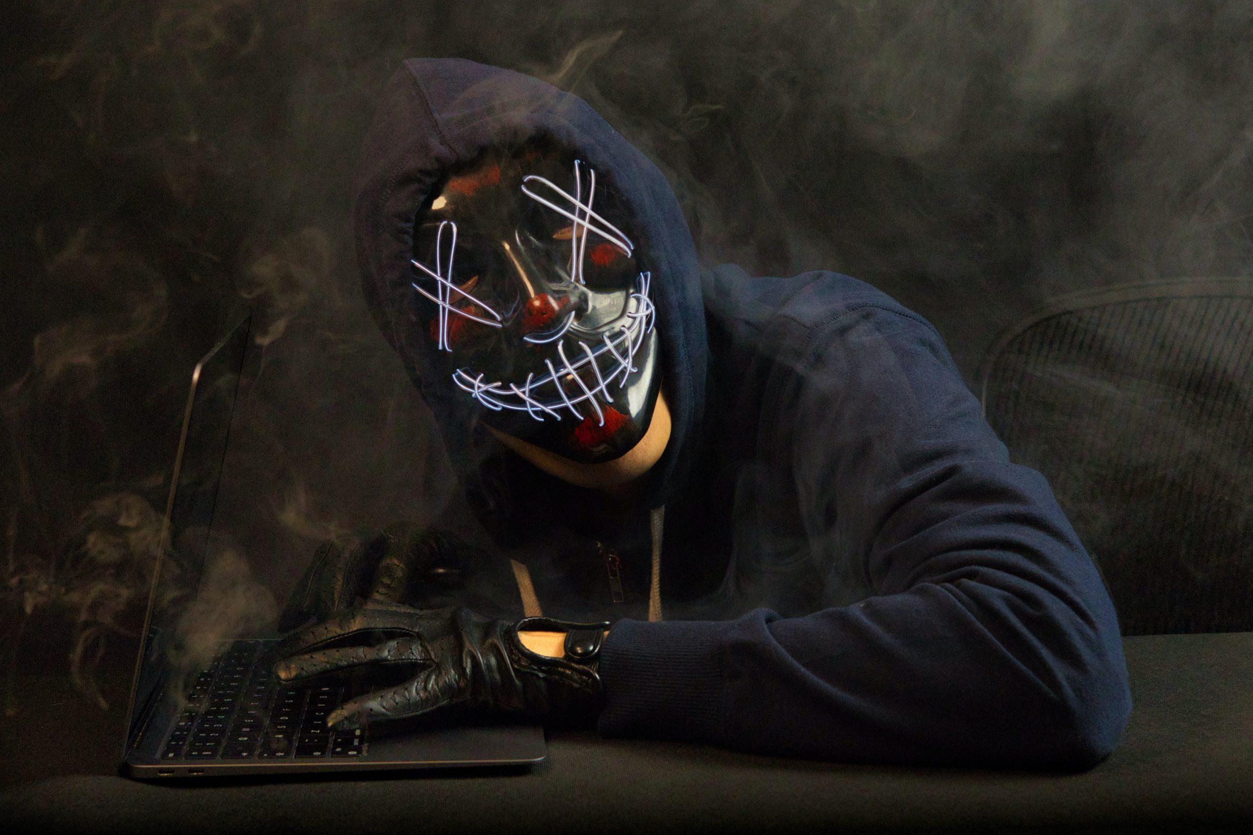 Hacker with Halloween mask on with laptop